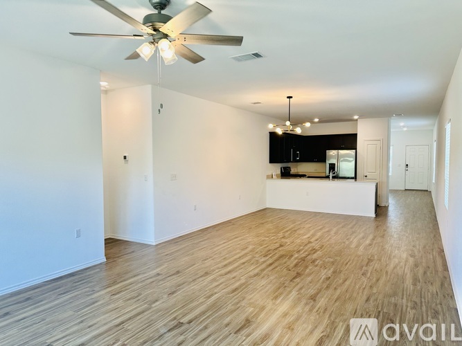 A room with a ceiling fan and wooden flooring.