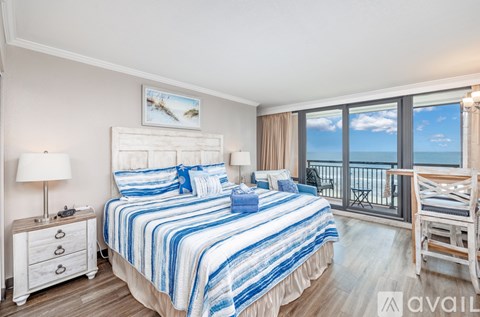A bedroom with a large bed and a view of the ocean.