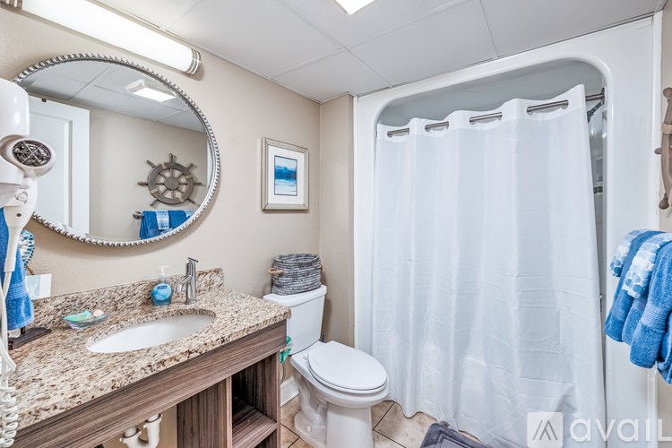 A bathroom with a toilet, sink, and shower.