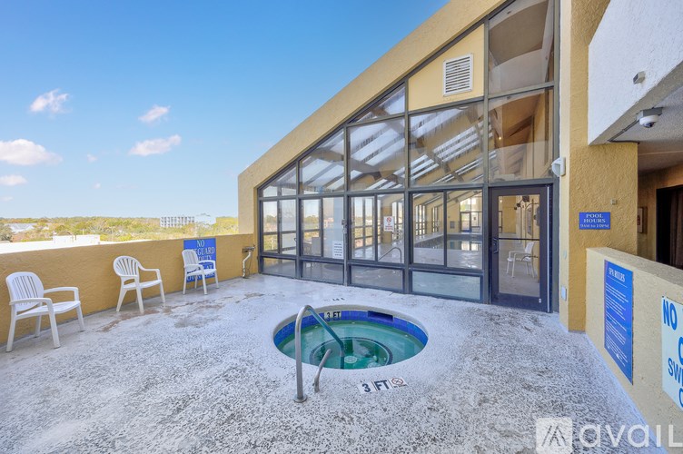 A hot tub is in the middle of a patio with chairs around it.