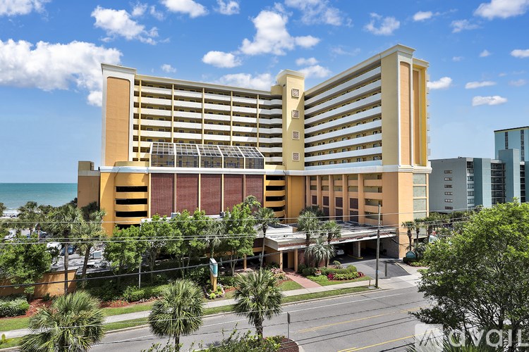 A large hotel building with a parking lot in front.