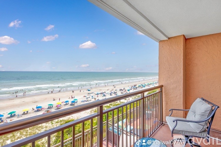 A balcony overlooks a crowded beach.