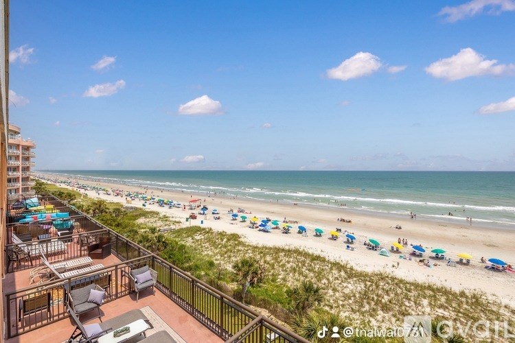 A beach scene with a clear blue sky and people enjoying the sun.