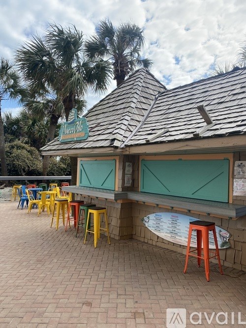 A restaurant with a surfboard menu board and colorful stools.