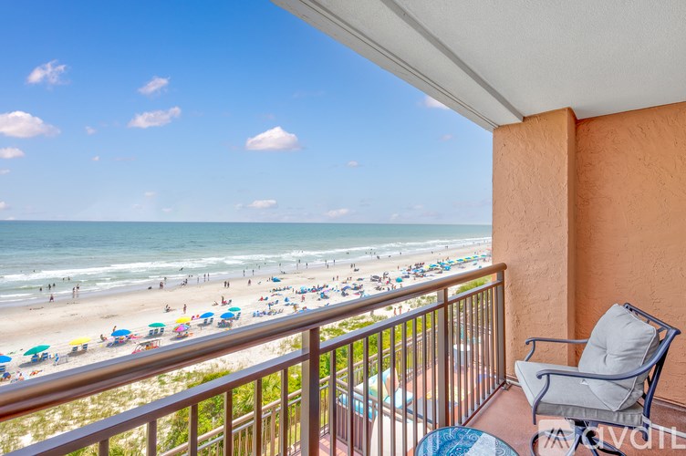 A balcony overlooks a crowded beach.
