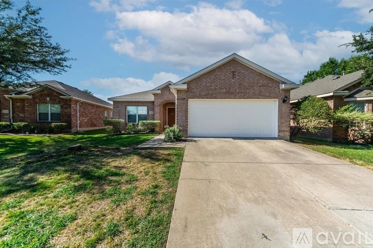 A house with a garage is surrounded by a grassy area.