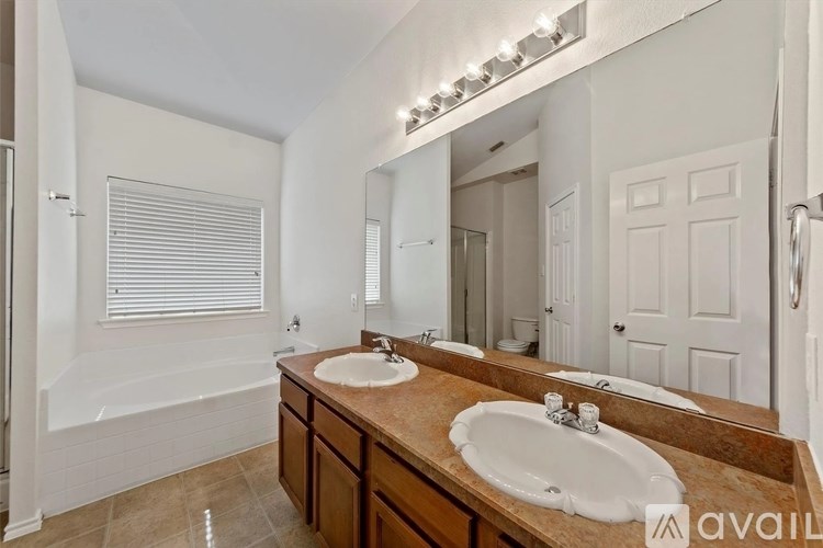 A bathroom with a double sink vanity and a large mirror.