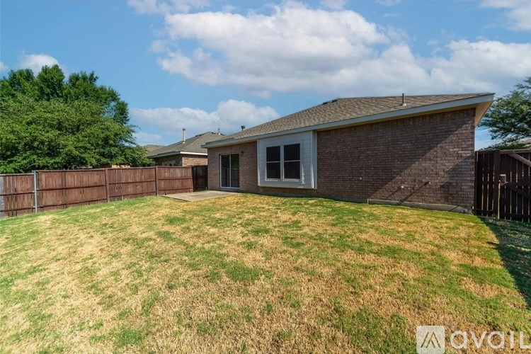 A house with a brown fence and a green lawn.