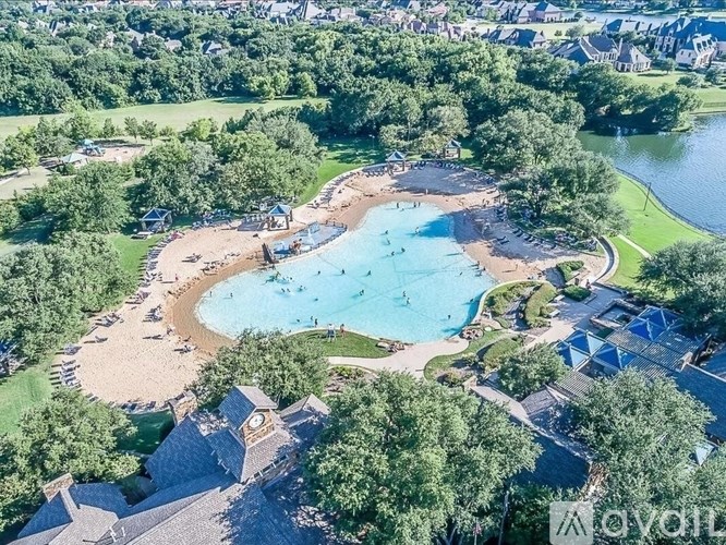 An aerial view of a resort with a large swimming pool surrounded by trees.