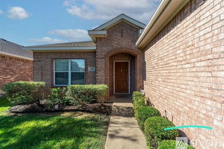 A brick house with a brown door and a window.