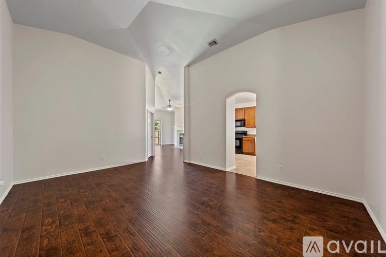 A spacious room with wooden floors and white walls.