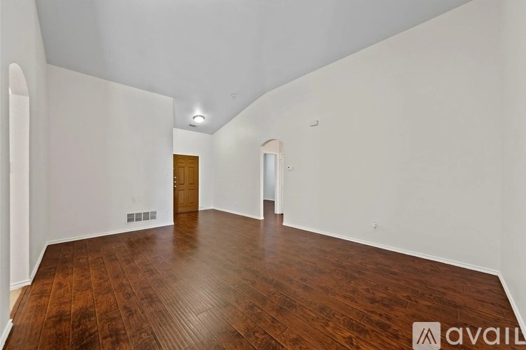 A room with wooden flooring and white walls.