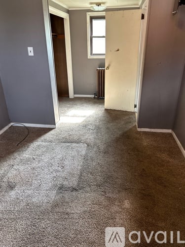 A room with a carpeted floor and a window.