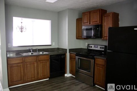 A kitchen with wooden cabinets and black appliances.