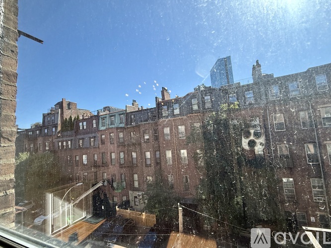 A view of a cityscape from a window with a reflection of a building.
