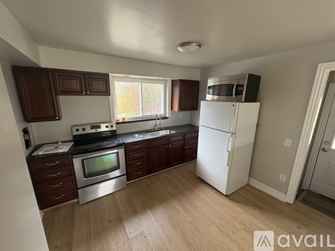 A kitchen with a white refrigerator and wooden cabinets.