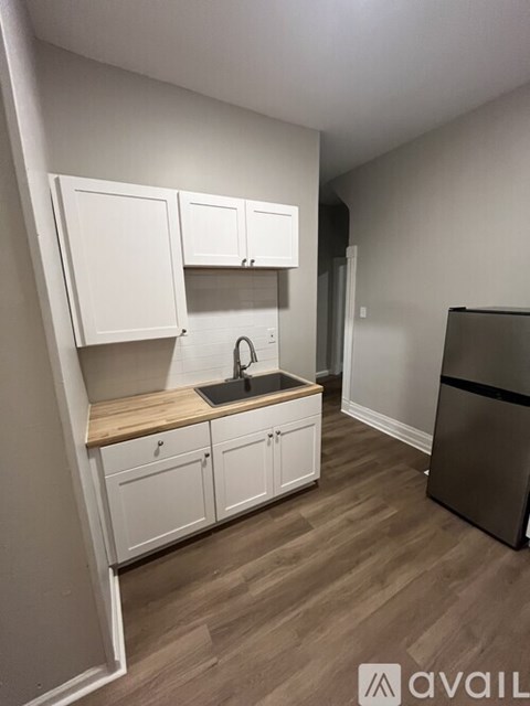 A kitchen with white cabinets and a wooden countertop.