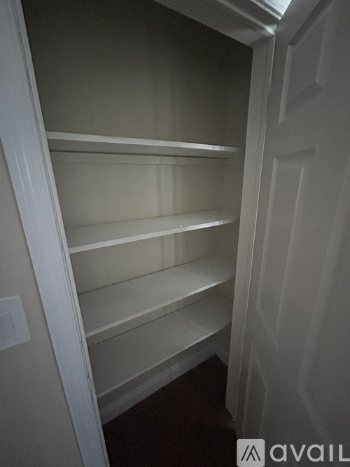 Empty white shelves in a pantry.