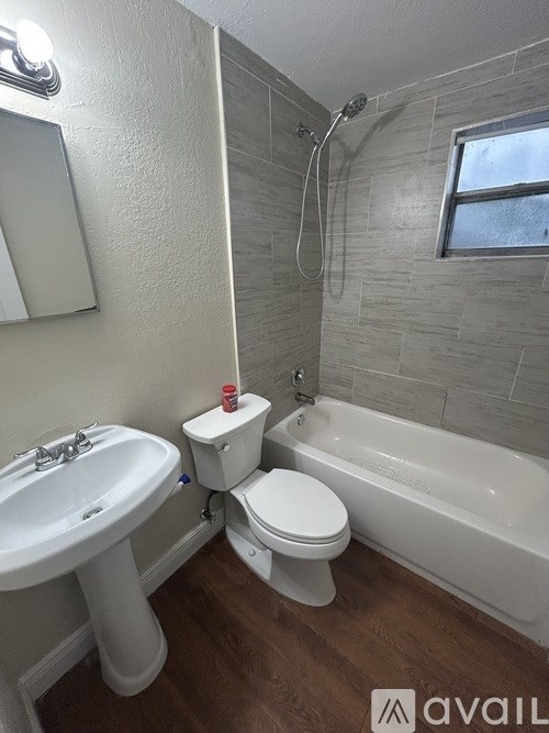A bathroom with a white toilet, sink, and bathtub.