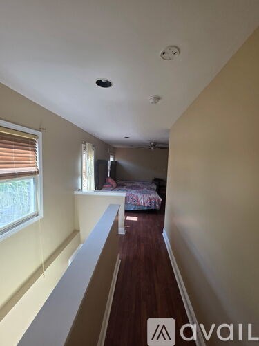 A long hallway with a bed on the right side.