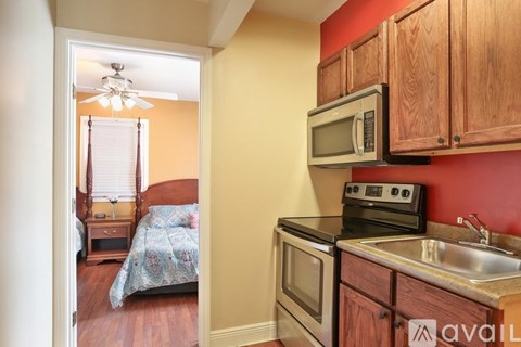 A kitchen with wooden cabinets and a stove top oven.