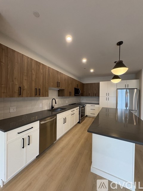 A modern kitchen with wooden cabinets and a black countertop.