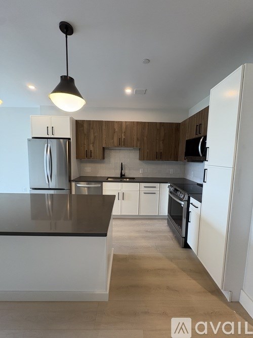 A kitchen with white cabinets and a black countertop.