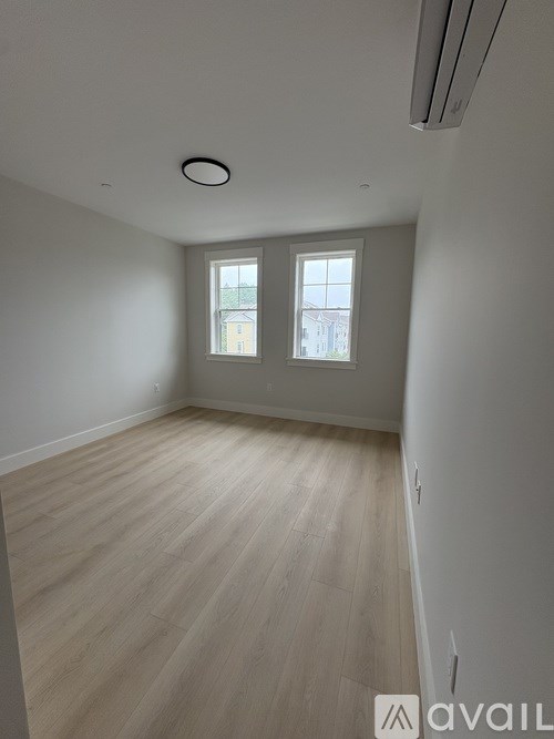 A room with wooden flooring and a window.