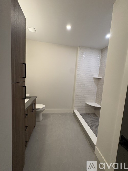 A bathroom with a toilet, sink, and a window with blinds.