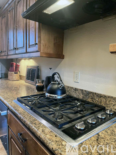 A kitchen with wooden cabinets and a black mat on the floor.