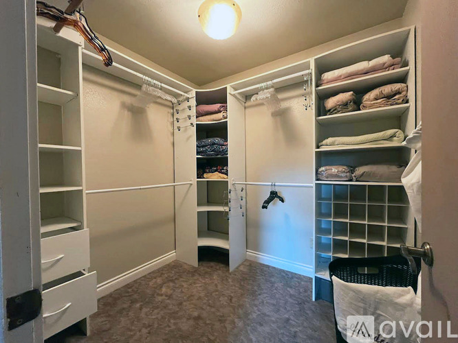 A bedroom with a large bed, a desk with a chair, and a ceiling fan.