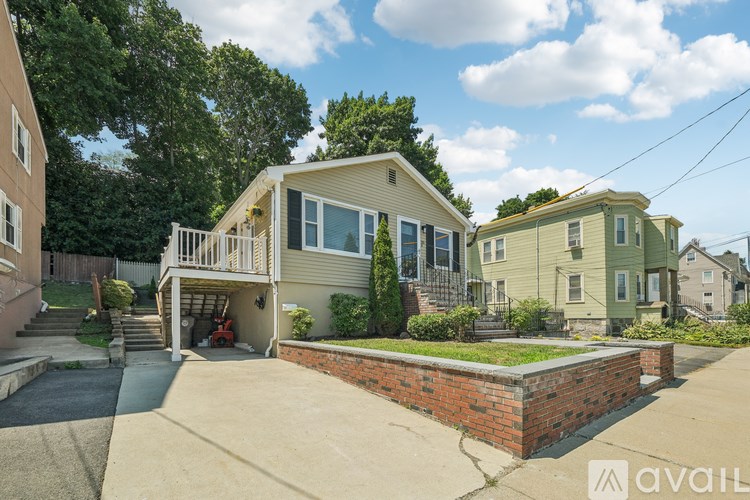 A house with a garage and a brick wall in front.