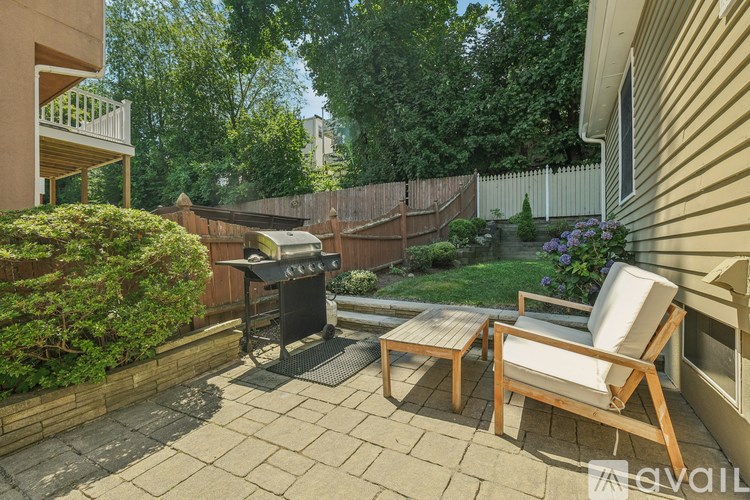 A patio with a table and chairs and a grill.