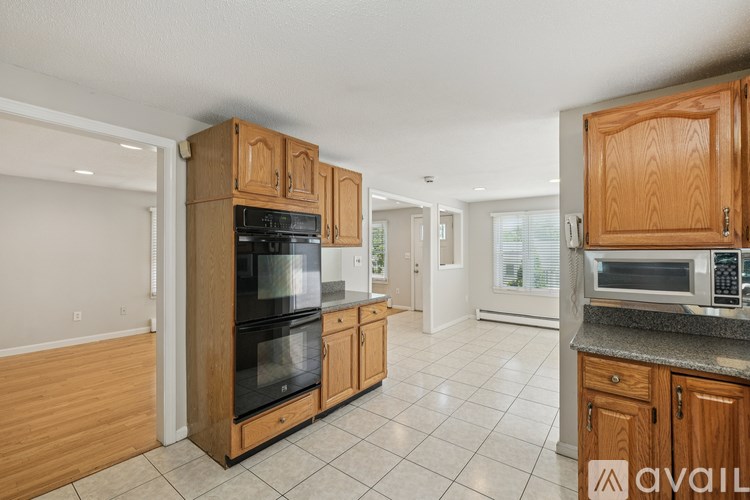 A kitchen with wooden cabinets and appliances is available for rent.