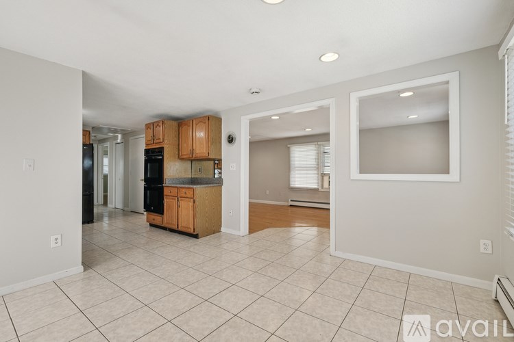 A kitchen with white walls and a tile floor.