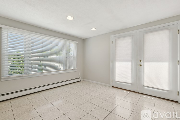 A room with white doors and windows with blinds.