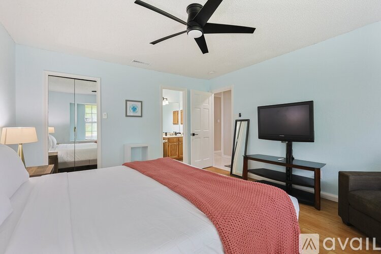 A bedroom with a large bed and a flat screen TV.