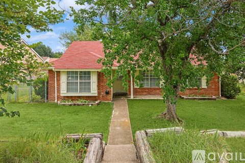 A house with a red roof and a tree in front.