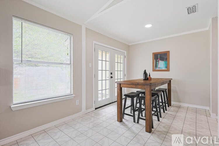 A dining room with a table and chairs.