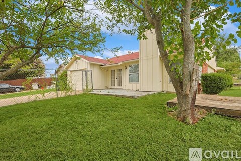 A house with a red roof and a tree in front.