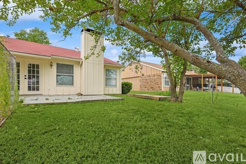 A house with a red roof and a tree in front.