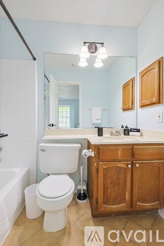 A bathroom with a toilet, sink, and mirror.