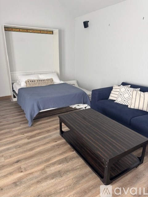 A bedroom with a bed, a couch, and a coffee table.