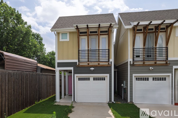 A row of houses with garages and wooden fences.