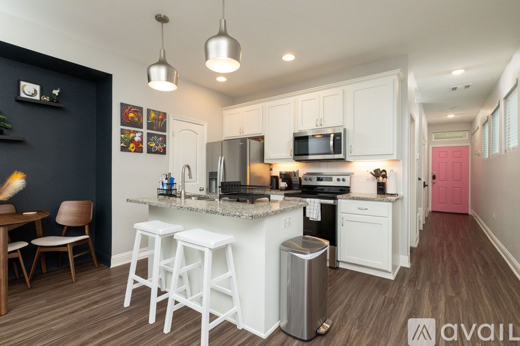 A kitchen with white cabinets and a black wall.