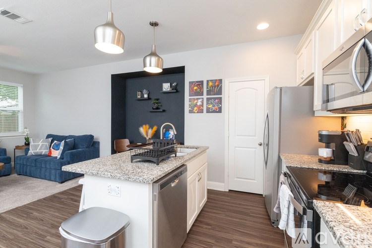 A modern kitchen with a blue sofa in the living room.