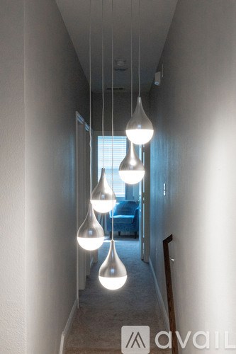 A hallway with white walls and hanging lights.