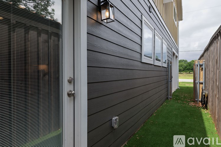 A grey house with a white door and a window.
