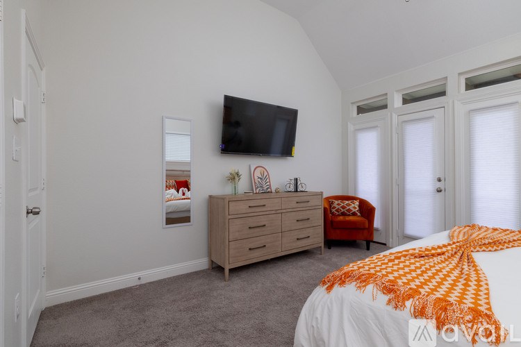 A bedroom with a bed, dresser, and television.