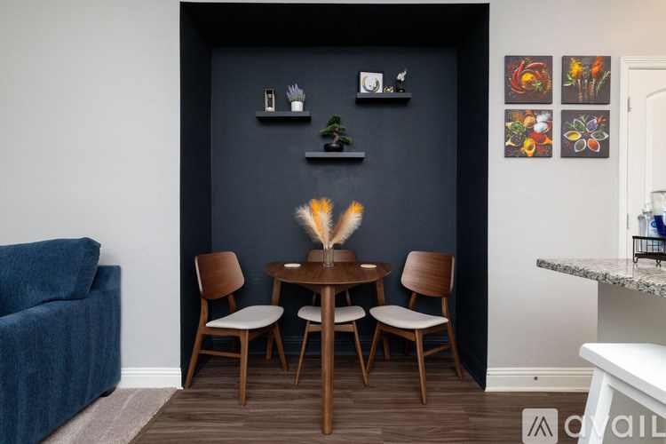 A living room with a blue couch, a wooden table, and chairs.